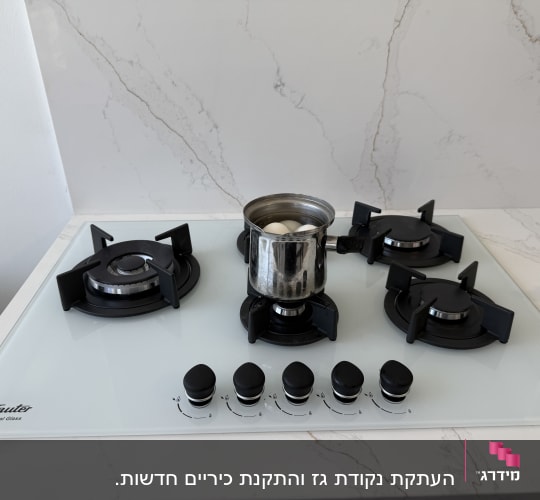כיריים גז עם סיר מתכת וביצים רותחות